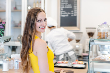 Woman in the pastry shop choosing sweet desserts