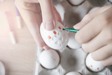 Drawing on Easter eggs using stencils. Children's art project. DIY concept. Step-by-step photo...