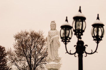 Obraz premium Buddhist Statue In Winter By Old Streetlamp, Black and White