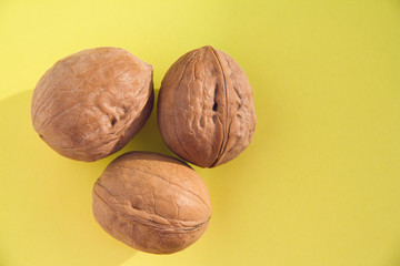 Three walnuts isolated on a colored background.