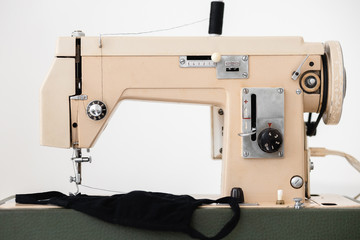 Beige sewing machine the process of sewing a protective medical mask at home is handmade