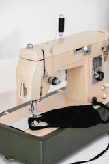 Beige sewing machine the process of sewing a protective medical mask at home is handmade