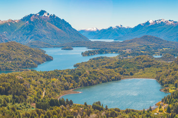 Naklejka na ściany i meble Andean lakes with mountains around blue sky and green vegetation in Argentine Patagonia in Bariloche