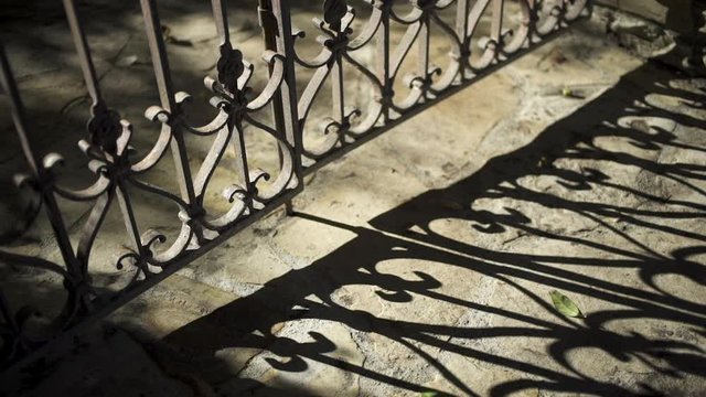 summer shadows from old garden gate on flagstones