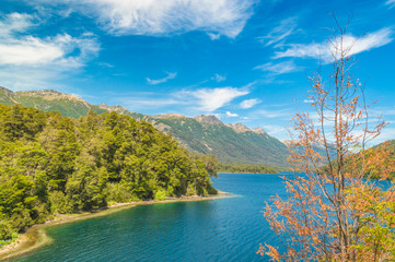 Andean lakes with mountains around blue sky and green vegetation in Argentine Patagonia in Bariloche
