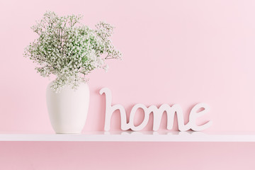 Home interior floral decor. Beautiful flowers in vase on pink wall background.