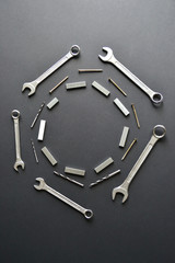 Wrenches, drills in a circle copy space on a black surface. focus on foreground.