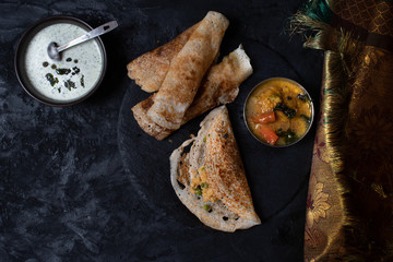 South Indian fermented pancake, lentil gravy and chutney on slate table