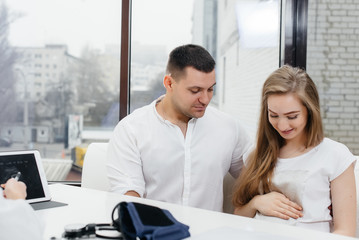 A young couple at a gynecologist's consultation after an ultrasound. Pregnancy, and health care