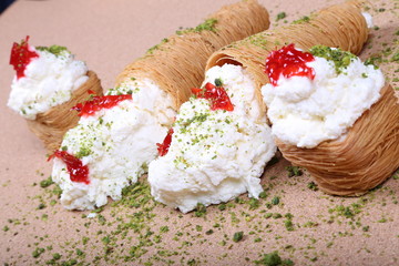 A slice piece of Esmalliyeh Ramadan Arabic sweet pastries & dessert with creamy & pistachio