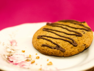 Cookie made with brazilian brigadeiro and chocolate on a white plate and pink background.