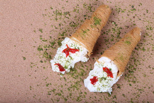 A slice piece of Esmalliyeh Ramadan Arabic sweet pastries & dessert with creamy & pistachio
