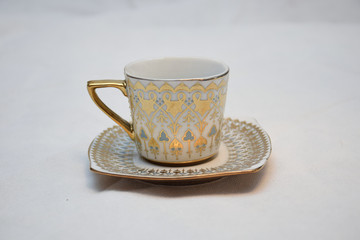 Mock up / design set of elegant and traditional teapot colorful white blue gold coffee cup & Tea cup on cup's plate beside the hot tea pot , design/ drink-ware isolated on white background