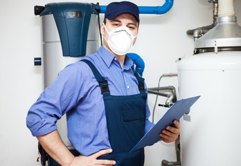 Technician servicing an hot-water heater during coronavirus pandemic - obrazy, fototapety, plakaty