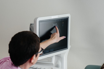 Doctor in the clinic near the ultrasound therapy device. Medical examination
