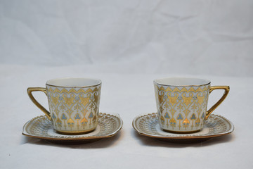 Mock up / design set of elegant and traditional teapot colorful white blue gold coffee cup & Tea cup on cup's plate beside the hot tea pot , design/ drink-ware isolated on white background