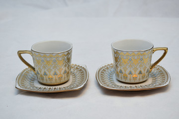 Mock up / design set of elegant and traditional teapot colorful white blue gold coffee cup & Tea cup on cup's plate beside the hot tea pot , design/ drink-ware isolated on white background