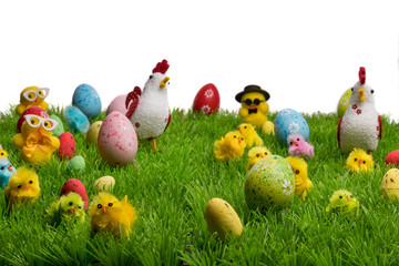 Decorative easter chickens, hens and eggs on plastic grass, forming a festive scene. Isolated on white background.
