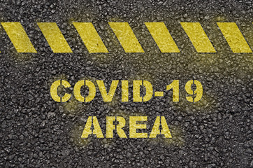 Covid-19 area warning on the black asphalt