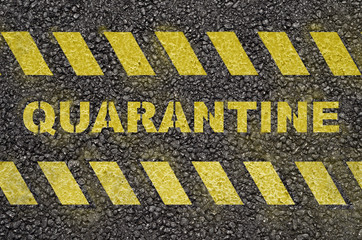 Quarantine text warning on the black asphalt
