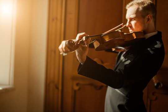 young caucasian talented gorgeous man un tux play violin, professional musician practice performance, use classic instrument . music concept