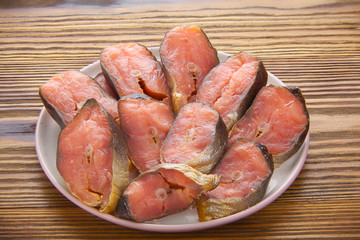 Hot smoked salmon fish on kitchen board on table