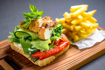 Grilled chicken breast on a toast with tomatoes