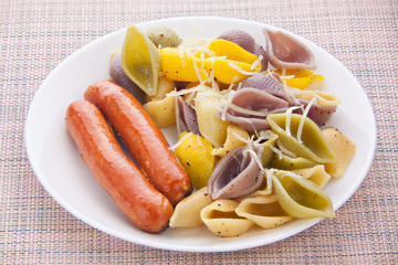 tasty appetizing pasta with German sausages on white plate