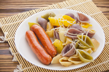 tasty appetizing pasta with German sausages on white plate