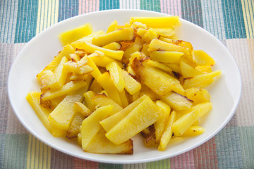 delicious fried potatoes on plate on white background