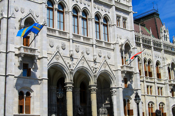 Facade of the Hungarian parliament building with the national flag of Hungary. Neo-Gothic landmark in the city of Budapest, Hungary