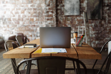 A laptop computer sitting on top of a wooden chair