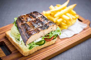 Grilled fish sandwich with cucumbers, tomatoes