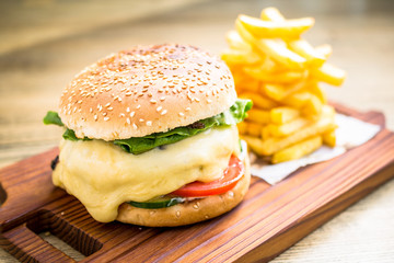 Fresh cheeseburger with melting cheese, tomatoes