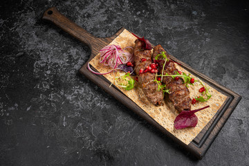 The concept of Georgian cuisine. Juicy lula kebab made from meat and spices. Serving dishes in a...