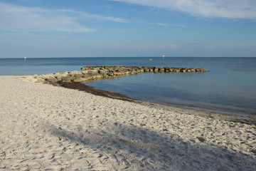 Bahía sin persona de arena blanca y mar y cielo azul 
