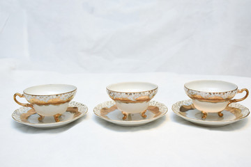 Mock up / design set of elegant and traditional teapot colorful white blue gold coffee cup & Tea cup on cup's plate beside the hot tea pot , design/ drink-ware isolated on white background