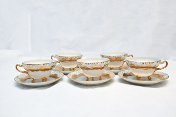 Mock up / design set of elegant and traditional teapot colorful white blue gold coffee cup & Tea cup on cup's plate beside the hot tea pot , design/ drink-ware isolated on white background