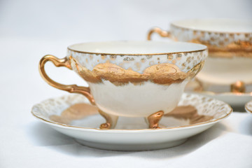 Mock up / design set of elegant and traditional teapot colorful white blue gold coffee cup & Tea cup on cup's plate beside the hot tea pot , design/ drink-ware isolated on white background