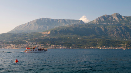 Fototapeta premium Taxi boat with tourists sailing through Kotor Bay, Montenegro, Europe, August 6, 2019 