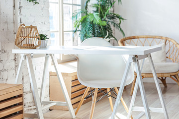 Stylish loft modern home office interior. Spacious design apartment with light walls large windows and writing desk. Clean modern decoration with elegant furniture in minimalist Scandinavian style.