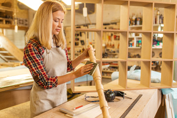 young hardworking skillful carpenter woman grinding piece of wood, handicraft maker, awesome woodworker behind workbench