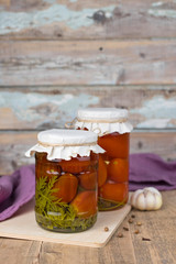 canned tomatoes in jar on the wooden table.