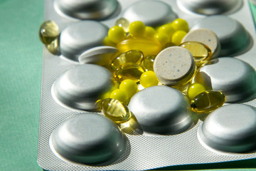 Spreading tablet of various shapes and colors, transparent yellow, large white. A bunch of pills....