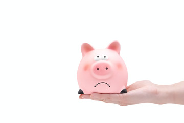 Piggy bank in form of sad pig on human hand isolated on white background. Clipping path. Copy space. Bankruptcy, financial crisis concept