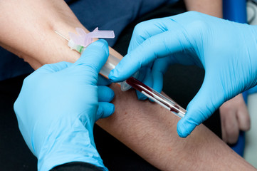 blue gloved hands taking a blood sample for testing