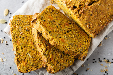 Healthy content. Loaf of pumpkin bread, seeds, sliced pieces, top view, close up.