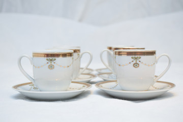 Mock up / design set of elegant and traditional teapot colorful white blue gold coffee cup & Tea cup on cup's plate beside the hot tea pot , design/ drink-ware isolated on white background