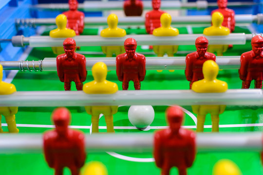 Futebol de mesa, pebolim de mesa. Vista de frente, bonecos de jogadores  de times vermelhos e amarelos posicionadas em uma mesa de  futebol.
