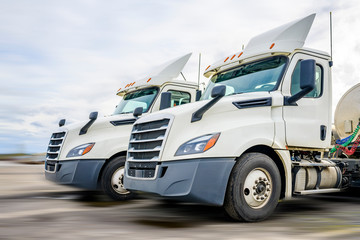 Day cab big rig white semi trucks with roof spoilers and tank semi trailers for carry liquid cargo...